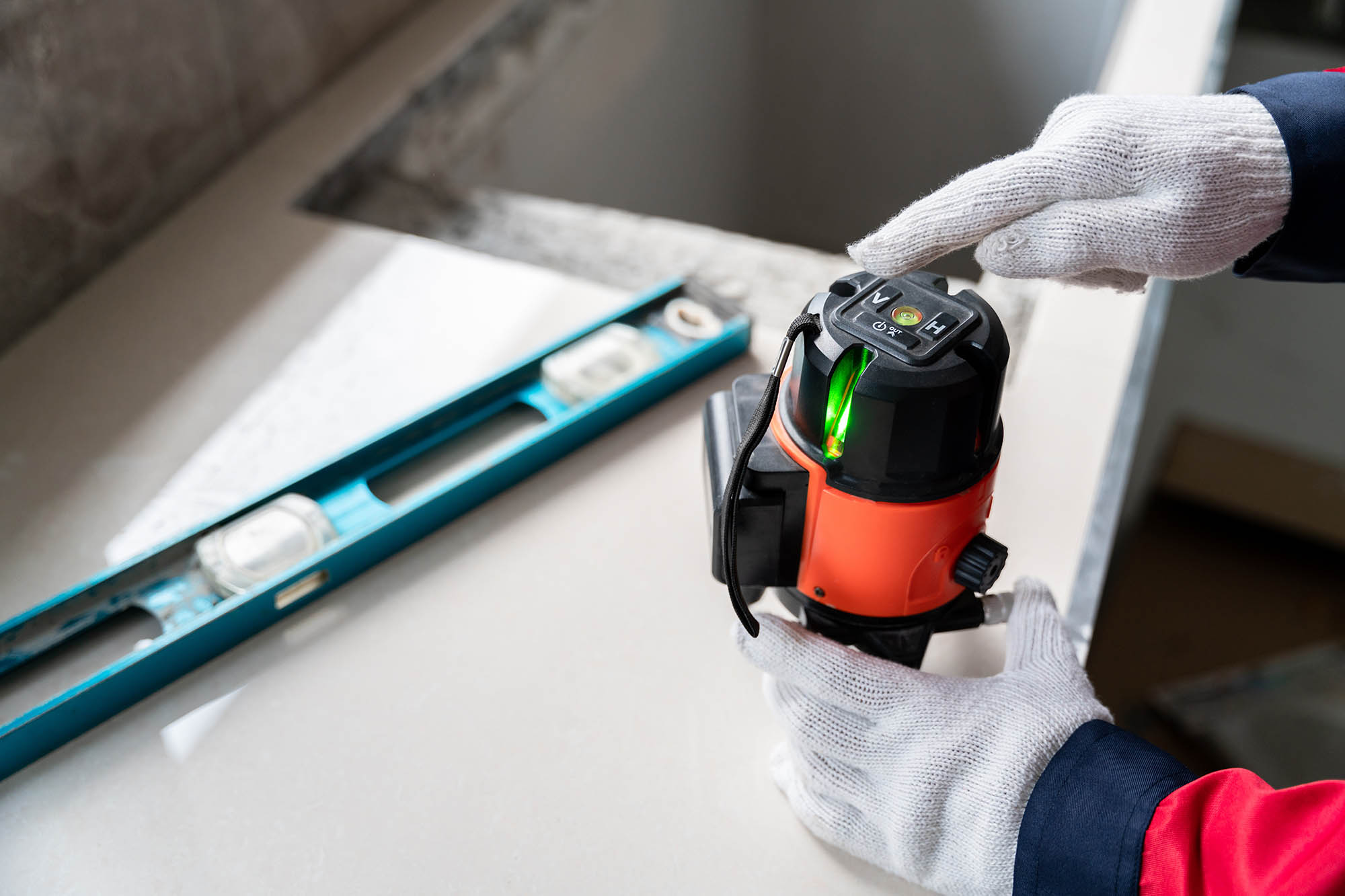 Hands of engineer or construction worker using laser level instr